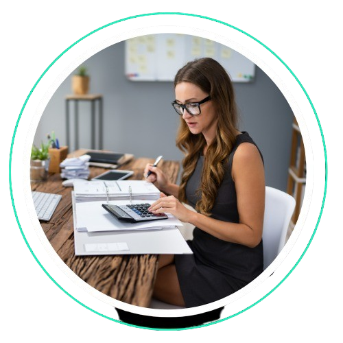 Woman using calculator and reviewing documents, representing accounting services in Dubai.